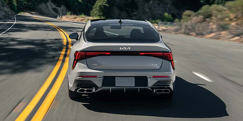2026 Kia K5 rear view driving on road
