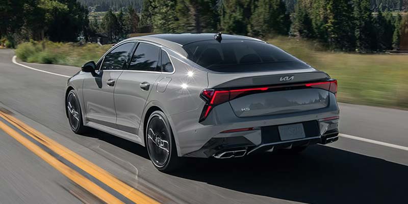2026 Kia K5 sedan rear view driving on road