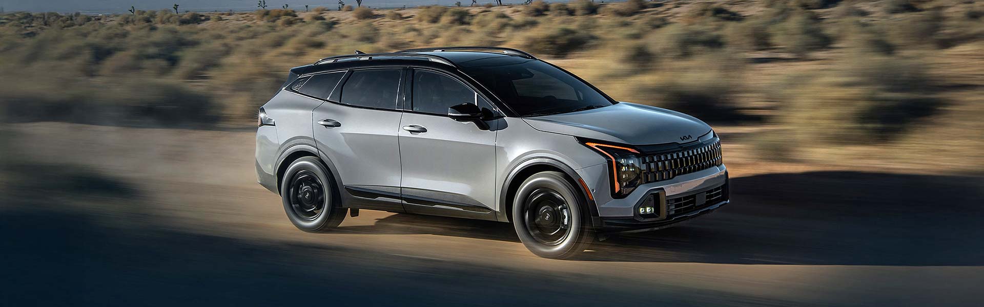 2026 Kia Sportage driving on a scenic road.